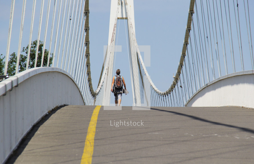 a man crossing a sloping bridge 