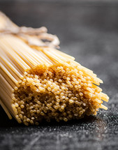 A pile of spaghetti dry on the table. Against a dark background. High quality photo