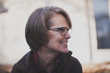 A woman wearing glasses and smiling
