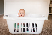 an infant in a laundry basket 
