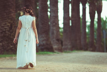girl walking in a white dress in a park 