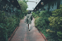 a woman walking on a brick sidewalk 