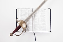 sword lying over the pages of a Bible