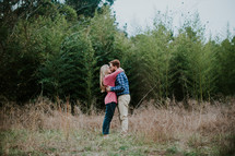 a couple kissing standing in a field 