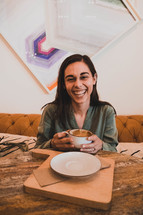 smiling woman holding a coffee cup 