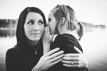 Little girl whispering to a woman