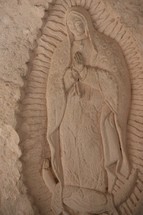 A carving in stone of Mary praying located in the Chapel of Saint Francis of Assisi 