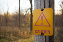 caution sign on a wood post 
