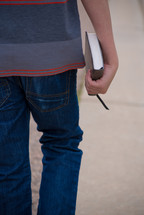 teen boy carrying a Bible 