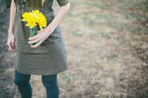 Holding a bouquet of daffodils.