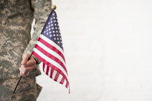 A soldier holds an American flag.
