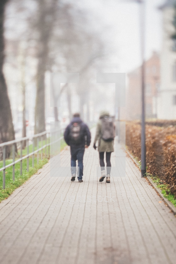 pedestrians walking on a foggy sidewalk 