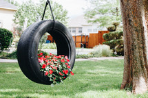 flowers planted in a tire swing 