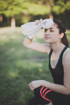 Woman wiping the sweat from her face outside.