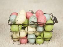 speckled eggs in a wire basket 