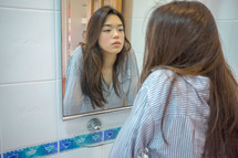 a young woman looking in a mirror 