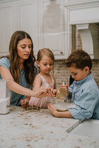 a mother baking cookies with her son and daughter 