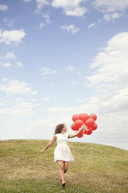 girl running with red balloons