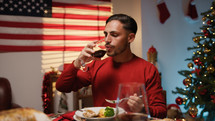 Man enjoying Thanksgiving dinner with USA flag in the background 