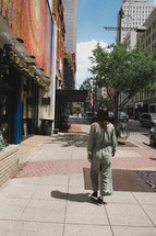 a woman standing on a sidewalk downtown 