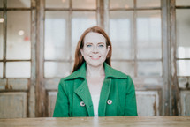 a smiling woman in a green blazer 
