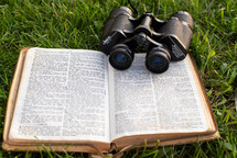 open Bible with binoculars 