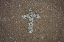 cross shape in shell on sand 