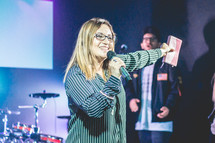 a woman holding a microphone and Bible 