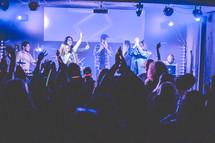 people holding a microphone and singing during a worship service 