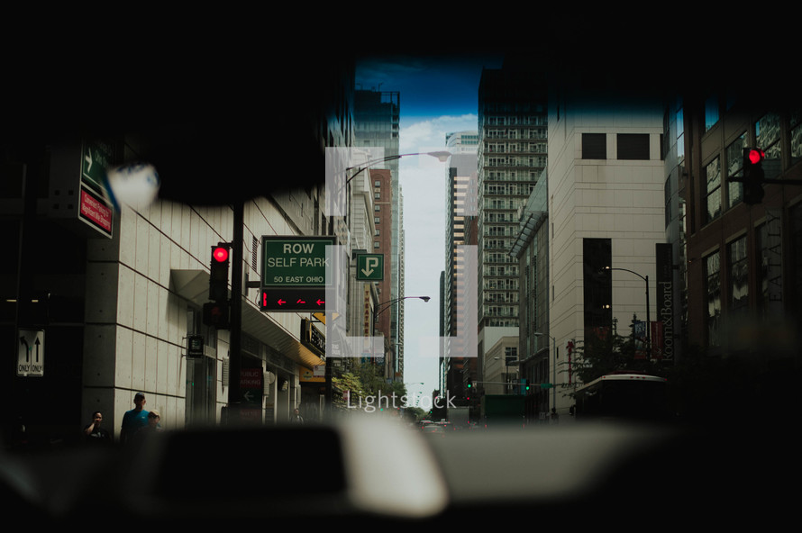 view of a city through the windshield of a car