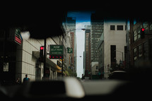 view of a city through the windshield of a car