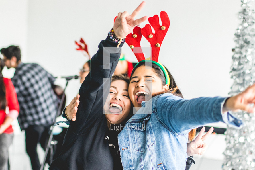 teens acting silly with Christmas reindeer antlers 