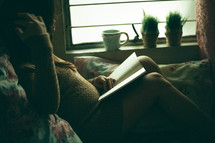 a woman lying in bed reading 
