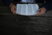hands holding a Bible reading 