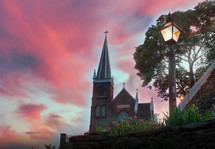 church with steeple under pink clouds at sunset 