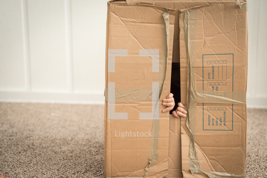 child playing with a cardboard box