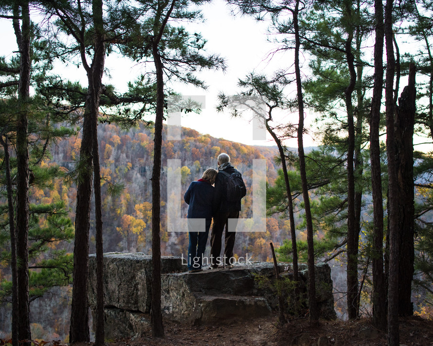 tender moment between a couple standing in a forest 