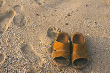 sandals and footprints on a beach 