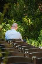 father of the groom anxiously waiting in a chair for a wedding to start