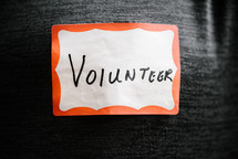 the word volunteer on a name badge 