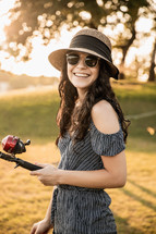 a smiling young woman holding a fishing pole 