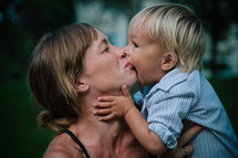 a toddler boy kissing his mother 