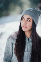 young woman standing outdoors in a beanie 