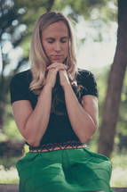 Woman praying outside.
