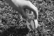 A child picking up an Easter egg at an Easter egg hunt, black and white