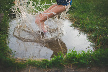 a boy jumping in a puddle 