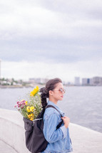 a young woman with flowers in her backpack 