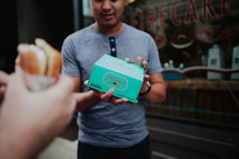 A man holding a box of cupcakes.