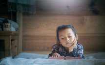 little girl reading the Bible with light in morning at home