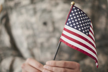 Small American flag held by an army soldier.